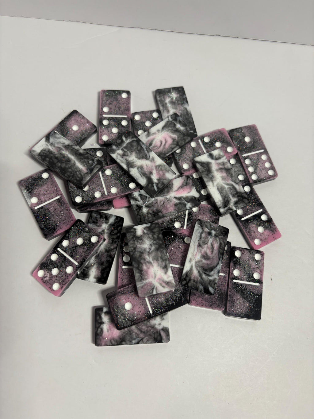 Black, pink, and white handmade resin Dominoes.