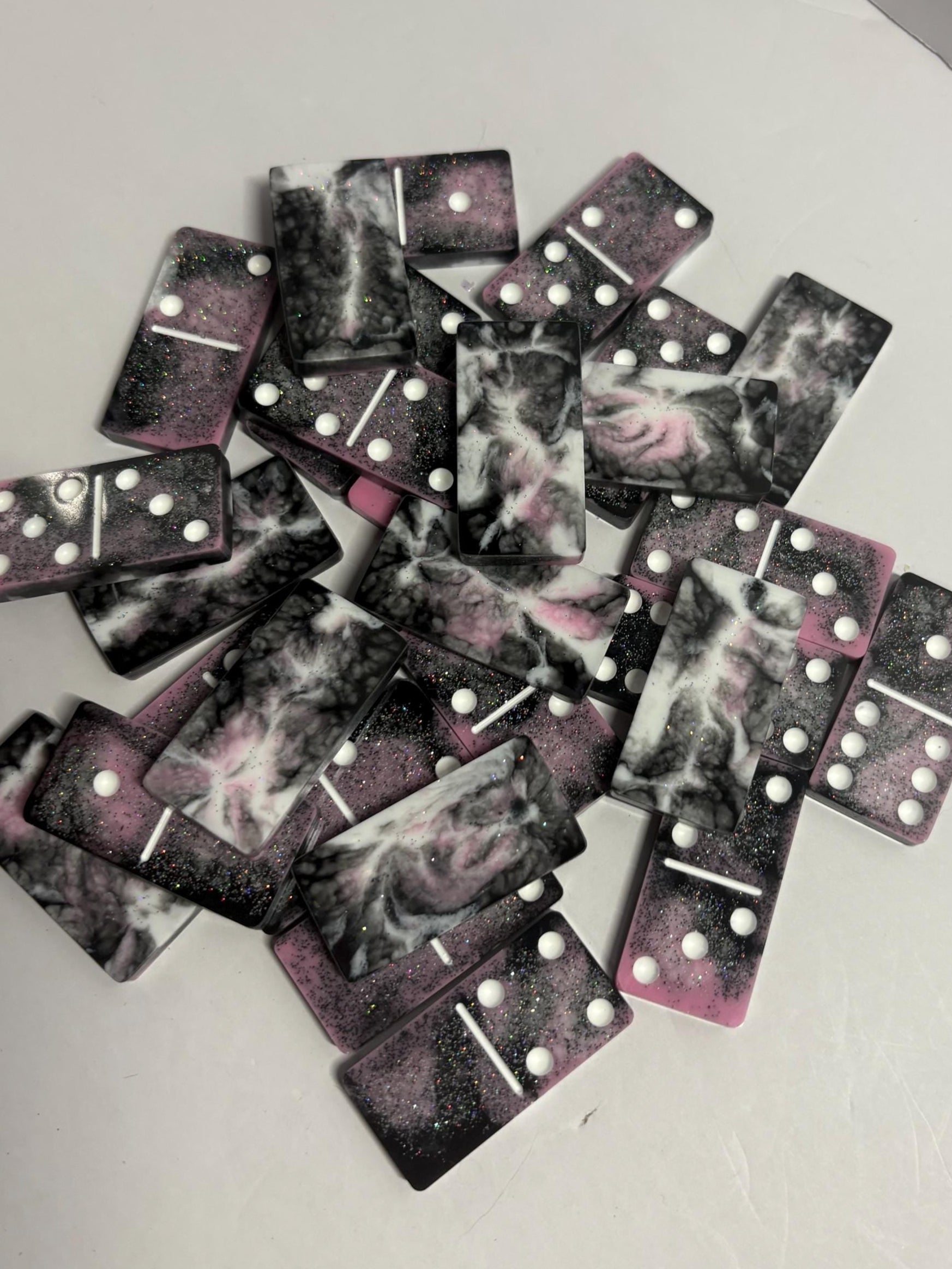 Black, pink, and white handmade resin Dominoes.